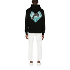FLEX SHOP Amiri black hoodie featuring a large panther graphic on the back, worn by a man with white trousers.