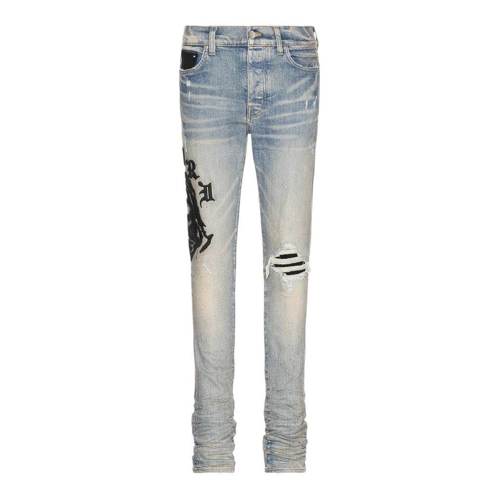 FLEX SHOP Amiri Wes Lang Reaper jeans in clay indigo blue denim with distressed knee and graphic logo print
