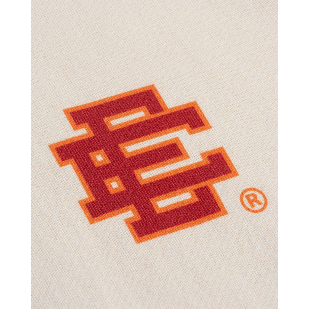FLEX SHOP Eric Emanuel cream fleece hoodie featuring a detailed red and orange flame logo graphic