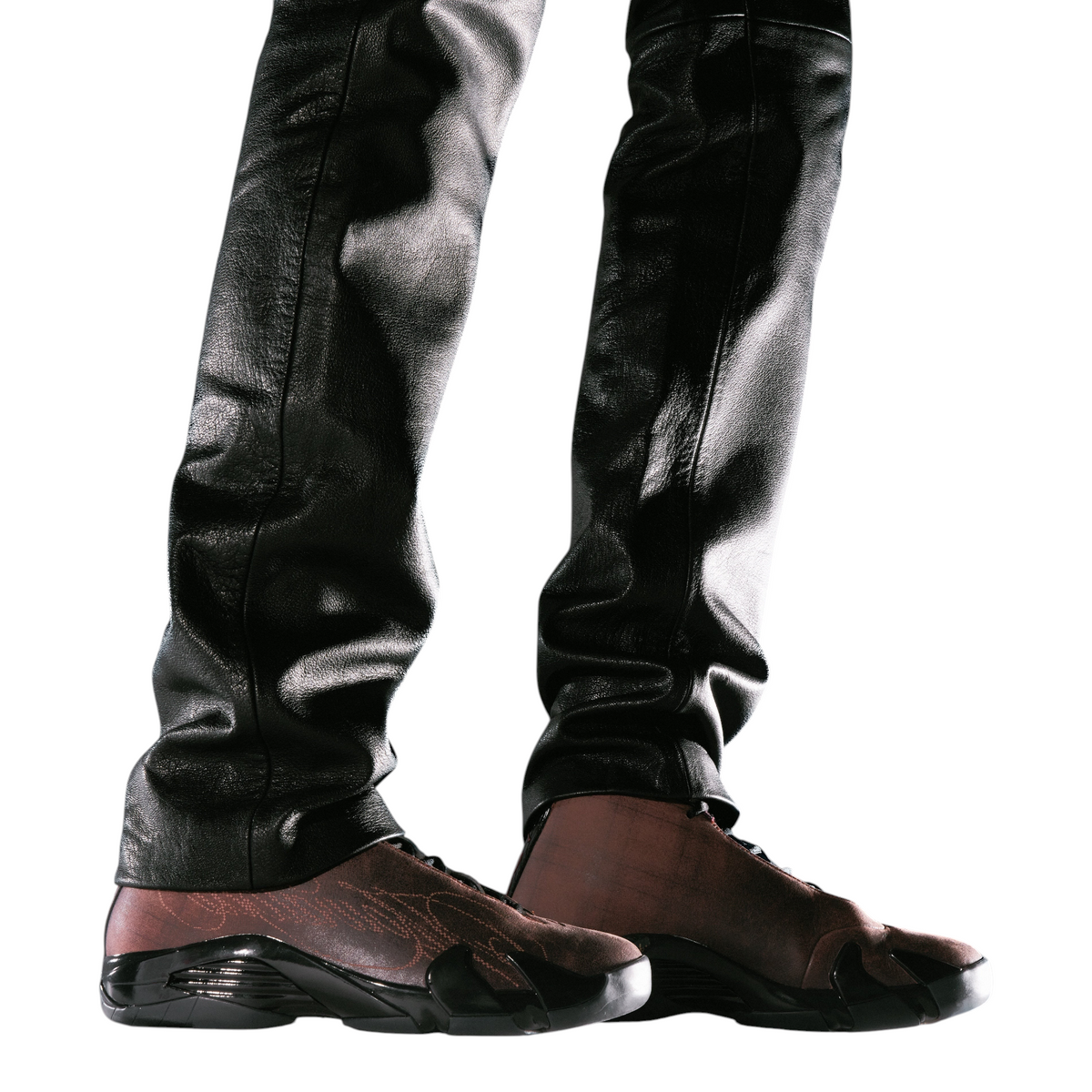 FLEX SHOP Jordan 14 Retro Mowalola sneakers in burnt red worn with black leather pants on a white background