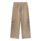 FLEX SHOP Righteous Sacred Heart brown sweatpants with graphic wing and heart design on the legs.