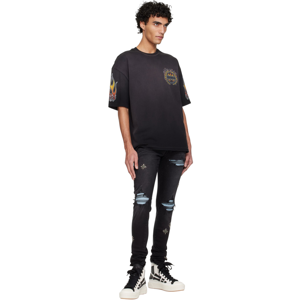 FLEX SHOP model wearing black graphic t-shirt, distressed black jeans, and Amiri Skel Court high-top sneakers