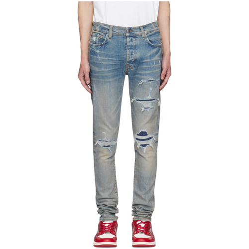 FLEX SHOP Amiri Clay Indigo distressed jeans with whiskering, contrast underlay rips, and logo appliqué detail.