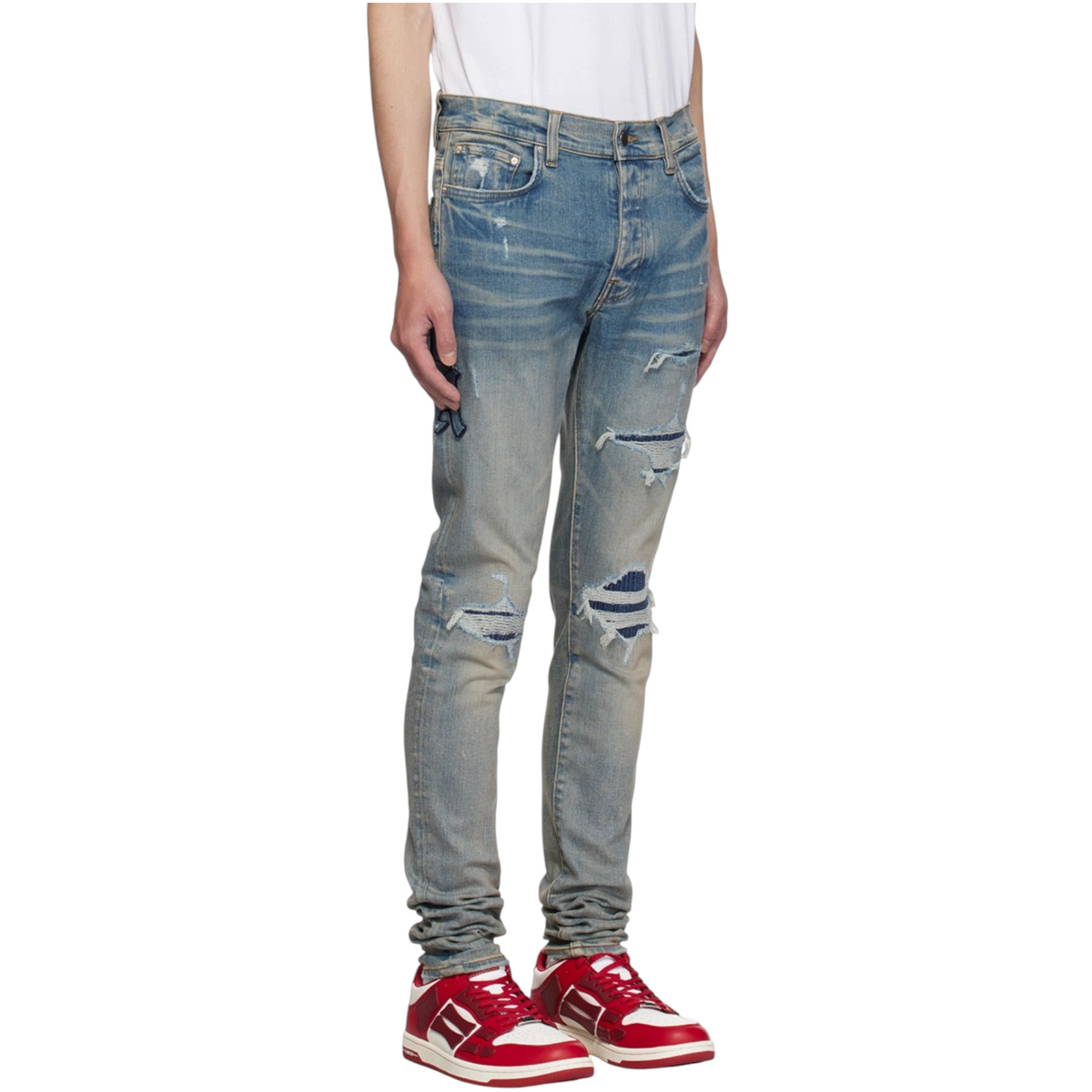 FLEX SHOP Amiri clay indigo distressed jeans with varsity repair patches, whiskering, and silver-tone hardware.